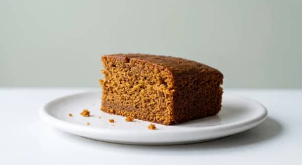Two slices of moist British ginger cake served with a cup of tea
