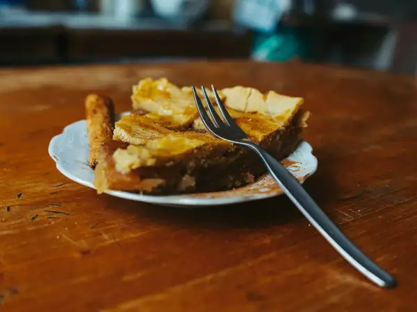 A plated portion of puff-pastry-topped chicken and leek pie served with garden peas.